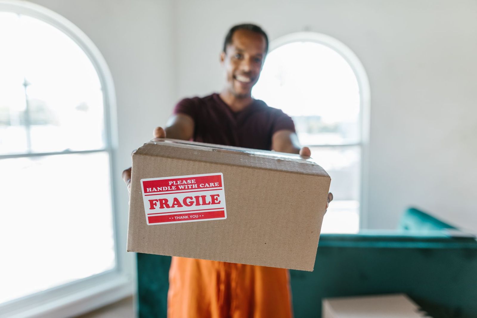 Umzugskarton mit der Aufschrift Fragile in den Händen